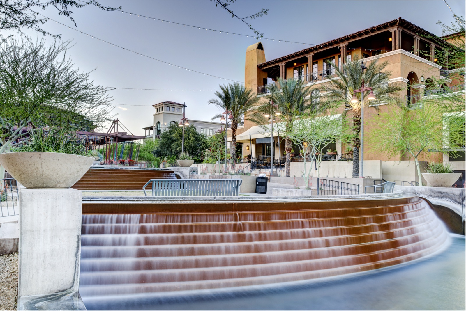 The Scottsdale Waterfront district with a fountain and palm trees